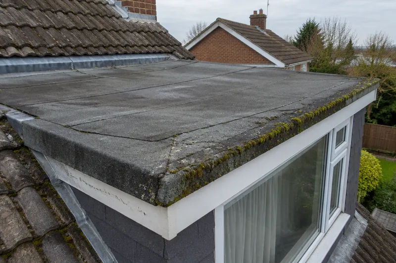 Flat roof repair in Barnsley: illustration of a felt dormer roof with cracked seams and moss on the edge